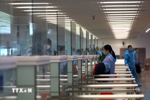 Hành khách làm thủ tục nhập cảnh trở về Việt Nam tại nhà ga T2 sân bay Nội Bài. (Ảnh: Huy Hùng/TTXVN)