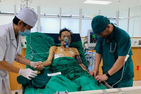 Bác sỹ kiểm tra sức khoẻ của bệnh nhân sau phẫu thuật. (Ảnh: PV/Vietnam+)