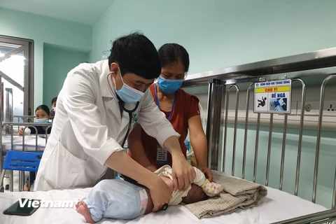 Bác sỹ Lê Thanh Chương khám cho trẻ 2 tháng tuổi ở Hà Đông mắc virus hợp bào hô hấp. (Ảnh: T.G/Vietnam+)