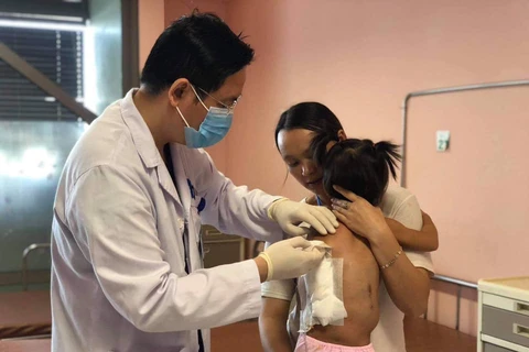 Bác sỹ kiểm tra sức khoẻ cho bé gái sau phẫu thuật. (Ảnh: PV/Vietnam+)
