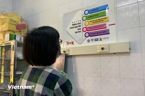 Người dân đọc thông tin tuyên truyền về phòng chống HIV/AIDS. (Ảnh: T.G/Vietnam+)