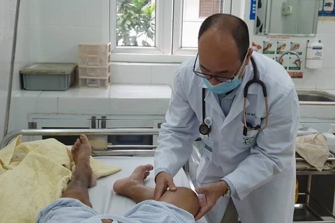 Phó giáo sư Đỗ Duy Cường khám cho bệnh nhân mắc Whitmore đang điều trị. (Ảnh: PV/Vietnam+)