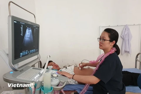 Bác sỹ Đàm Thanh Huyền thuộc dự án bác sỹ trẻ tình nguyện siêu âm cho một bệnh nhân tại Bệnh viện đa khoa huyện Quỳnh Nhai, Sơn La. (Ảnh: PV/Vietnam+)
