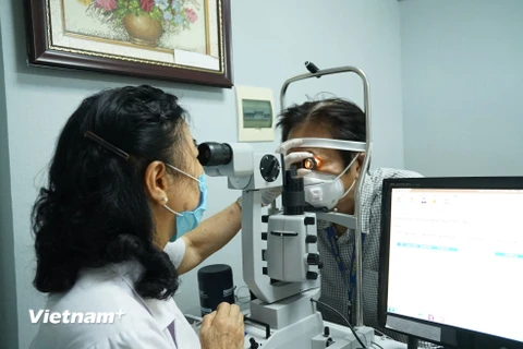Khám, kiểm tra mắt cho bệnh nhân. (Ảnh: PV/Vietnam+)