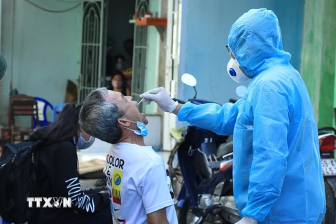 Nhân viên y tế lấy mẫu xét nghiệm người dân tại Quận 6, Thành phố Hồ Chí Minh. (Ảnh: Đinh Hằng/TTXVN)