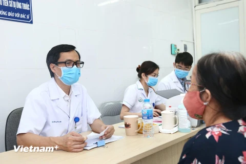 Phó giáo sư Đồng Văn Hệ khám cho một bệnh nhân. (Ảnh: PV/Vietnam+)