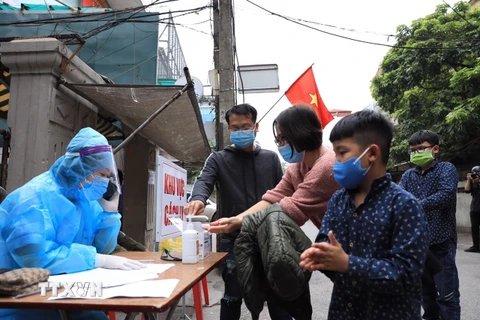 Người dân tại khu vực phong toả ở Hà Nội thực hiện các biện pháp phòng chống COVID-19. (Ảnh: Minh Đức/TTXVN)