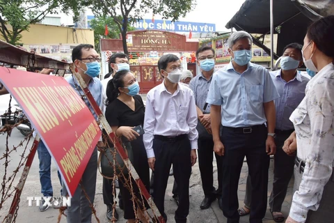 Thứ trưởng Bộ Y tế Nguyễn Trường Sơn thăm hỏi cán bộ địa phương trong công tác chống dịch. (Ảnh: Đinh Hằng/TTXVN)