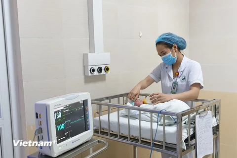 Nhân viên y tế chăm sóc cho trẻ sơ sinh tại Bệnh viện Đa khoa Đức Giang. (Ảnh: PV/Vietnam+)