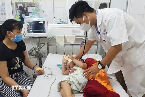 Bệnh nhi mắc bệnh tay chân miệng được bác sĩ Bệnh viện Phụ sản- Nhi Đà Nẵng khám. (Ảnh: Văn Dũng/TTXVN)