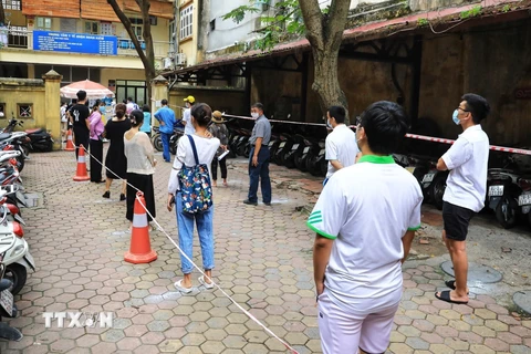 Người dân quận Hoàn Kiếm đến làm xét nghiệm COVID-19 xếp hàng đảm bảo giãn cách phòng chống dịch theo quy định. (Ảnh: Thành Đạt/TTXVN)
