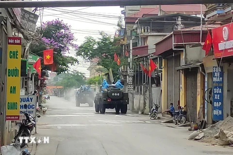 Lực lượng chức năng Bộ Tư lệnh Thủ đô Hà Nội sử dụng xe chuyên dụng phun thuốc khử khuẩn tại huyện Thường Tín. (Ảnh: TTXVN phát)