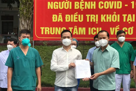 Bác sỹ Trần Thanh Linh và ông Mai Sơn - Phó Chủ tịch tỉnh Bắc Giang trao công bố khỏi bệnh cho bệnh nhân N.V.G. (Ảnh: PV/Vietnam+)
