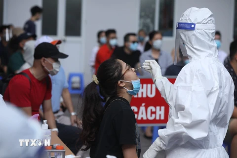 Nhân viên y tế quận Hai Bà Trưng lấy mẫu xét nghiệm COVID-19 cho các trường hợp trở về từ Thành phố Hồ Chí Minh. (Ảnh: Minh Quyết/TTXVN)
