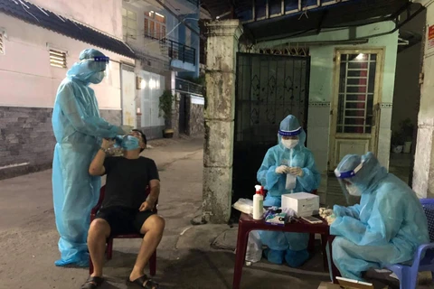 Sinh viên Trường Đại học Kỹ thuật y tế Hải Dương lấy mẫu bệnh phẩm cho người dân tại Thành phố Hồ Chí Minh. (Ảnh:PV/Vietnam+)