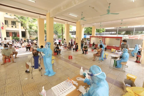 Nhân viên y tế quận Hai Bà Trưng phối hợp với y tế phường Bạch Mai lấy mẫu xét nghiệm COVID-19 cho các trường hợp thuộc khu vực có nguy cơ cao. (Ảnh: Minh Quyết/TTXVN)