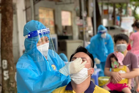 Nhân viên y tế lấy mẫu xét nghiệm cho người dân tại Hà Nội. (Ảnh: PV/Vietnam+)