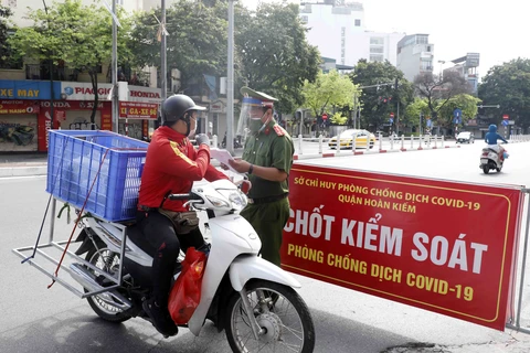 Kiểm tra giấy tờ người tham gia giao thông tại chốt kiểm soát trên phố Điện Biên Phủ. (Ảnh: Trần Việt/TTXVN)