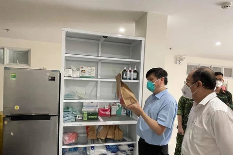 Bộ trưởng Bộ Y tế kiểm tra túi thuốc điều trị ngoại trú cho người nhiễm COVID-19 tại nhà. (Ảnh: PV/Vietnam+)