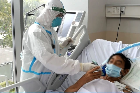 Nhân viên y tế chăm sóc cho bệnh nhân mắc COVID-19. (Ảnh: PV/Vietnam+)