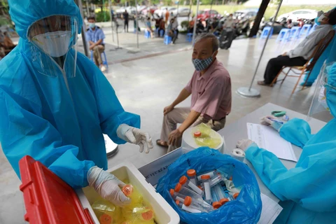 Nhân viên y tế lấy mẫu xét nghiệm cho người dân tại Hà Nội. (Ảnh: TTXVN/Vietnam+)