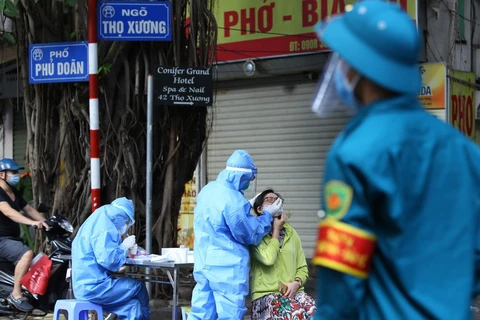 Nhân viên y tế lấy mẫu xét nghiệm cho người dân khu vực lân cận Bệnh viện Việt Đức. (Ảnh: Hoàng Hiếu/TTXVN)