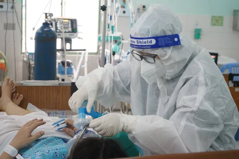Nhân viên y tế chăm sóc cho bệnh nhân mắc COVID-19.(Ảnh: PV/Vietnam+)