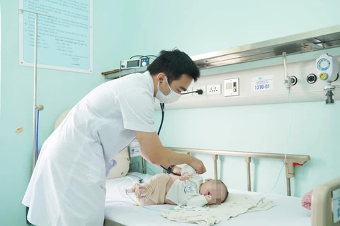 Bác sỹ khám cho trẻ mắc virus hợp bào hô hấp tại Bệnh viện Nhi Trung ương. (Ảnh: PV/Vietnam+)