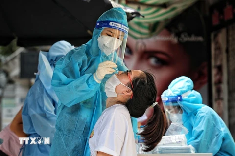 Nhân viên y tế lấy mẫu cho người dân. (Ảnh: TTXVN/Vietnam+)