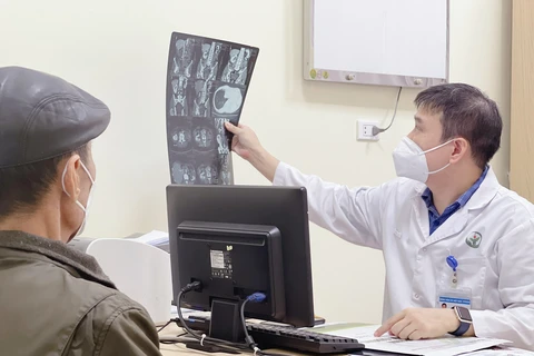 Bác sỹ tư vấn cho bệnh nhân tới khám bệnh lý tuyến tiền liệt. (Ảnh: PV/Vietnam+)