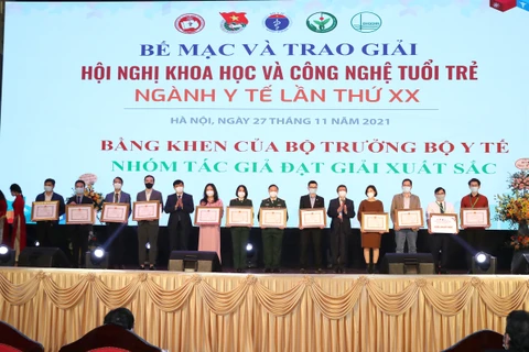 Bộ trưởng Bộ Y tế trao bằng khen cho các tác giả đoạt giải Xuất sắc. (Ảnh: PV/Vietnam+)