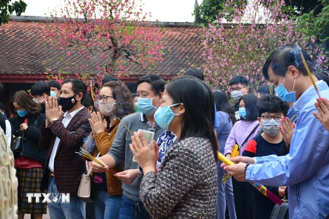 Người dân đeo khẩu trang khi đến chỗ đông người để phòng ngừa dịch bệnh COVID-19. (Ảnh: Công Luật/TTXVN)