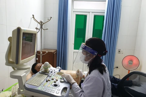 Bác sỹ siêu âm cho bệnh nhân tại Bệnh viện Đa khoa huyện Thường Xuân. (Ảnh: T.G/Vietnam+)