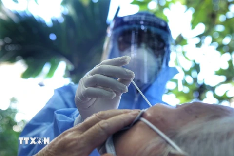 Nhân viên y tế lấy mẫu cho người dân. (Ảnh: TTXVN/Vietnam+)