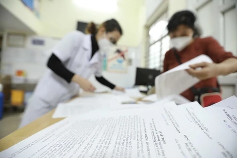 Người dân Hà Nội tới các trạm y tế làm các thủ tục xác nhận FO. (Ảnh: TTXVN/Vietnam+)