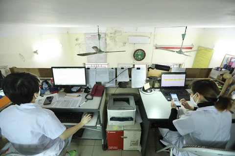 Nhân viên tại các trạm y tế làm hồ sơ quản lý F0 tại nhà. (Ảnh: TTXVN/Vietnam+)
