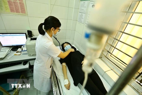 Bác sỹ khám sàng lọc bệnh sốt xuất huyết cho một trường hợp tại Hà Nội. (Ảnh: Minh Quyết/TTXVN)