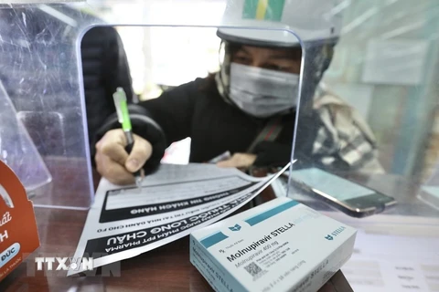 Người dân mua thuốc điều trị COVID-19. (Ảnh: TTXVN/Vietnam+)