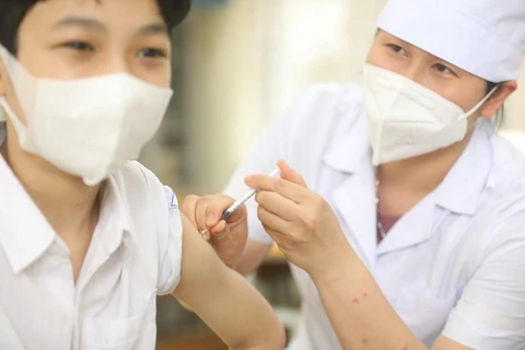 Nhân viên y tế quận Hà Đông tiêm vaccine phòng COVID-19 cho học sinh lớp 6 tại điểm tiêm chủng trường THCS Lê Quý Đôn. (Ảnh: Minh Quyết/TTXVN)