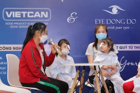 Các gia đình bệnh nhi có hoàn cảnh khó khăn chia sẻ sau khi trẻ được phẫu thuật về mắt. (Ảnh: PV/Vietnam+)