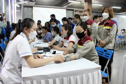 Các bác sỹ khám bệnh ậu COVID-19, tư vấn sức khỏe cho công nhân tại các tỉnh. (Ảnh: PV/Vietnam+)