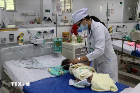 Bác sĩ Bệnh viện Sản-Nhi Kiên Giang khám, điều trị cho trẻ sốt xuất huyết. (Ảnh: Lê Huy Hải/TTXVN)