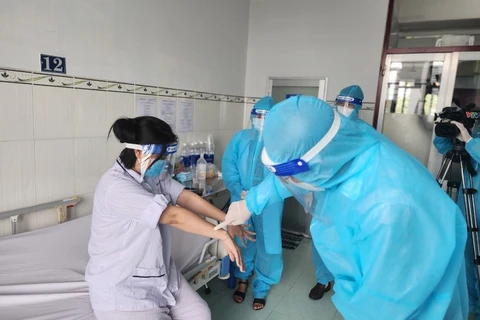 Lãnh đạo Cục Y tế dự phòng thăm hỏi, động viên người bệnh mắc đậu mùa khỉ đầu tiên tại Việt Nam. (Ảnh: TTXVN phát)