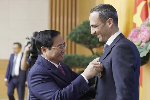 Thủ tướng Phạm Minh Chính trao Huy chương Hữu nghị của Chủ tịch nước cho ông John Paul Pullicino. (Ảnh: Dương Giang/TTXVN)