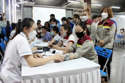 Nhân viên y tế kiểm tra, theo dõi sức khoẻ huyết áp, tim mạch cho người dân. (Ảnh: PV/Vietnam+)