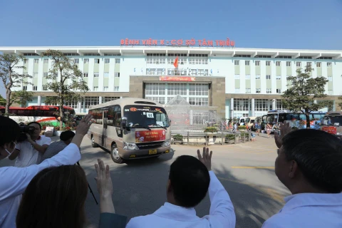 Các y bác sỹ tiễn bệnh nhân lên các chuyến xe về quê dịp Tết. (Ảnh: PV/Vietnam+)