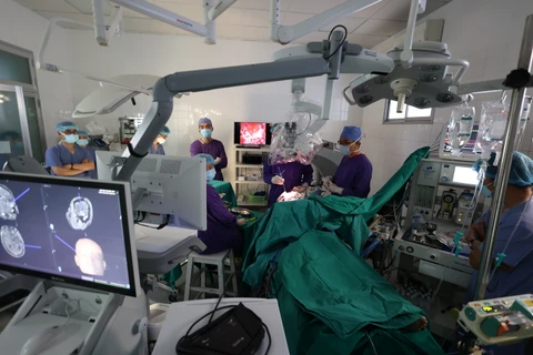 Các bác sỹ thực hiện một ca phẫu thuật thần kinh bằng công nghệ hiện đại cho bệnh nhân. (Ảnh: PV/Vietnam+)