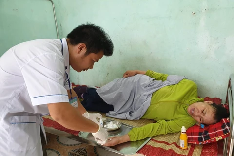 Nhân viên y tế tại Trạm y tế xã Quảng Phương (Quảng Trạch, Quảng Bình) khám chữa bệnh cho người dân. (Ảnh: T.G/Vietnam+)
