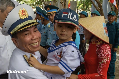 Chuẩn đô đốc Phạm Văn Hùng - Phó Tham mưu trưởng Quân chủng hải quân thăm hỏi sức khỏe một cháu bé trên đảo Trường Sa. (Ảnh: Tuấn Anh/Vietnam+)