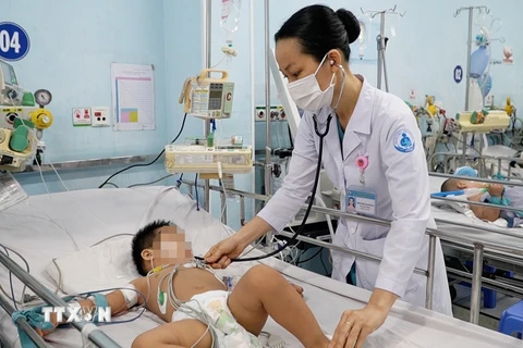 Bác sỹ Bệnh viện Nhi đồng 1 Thành phố Hồ Chí Minh thăm khám cho trẻ mắc bệnh tay chân miệng. (Ảnh: TTXVN phát)